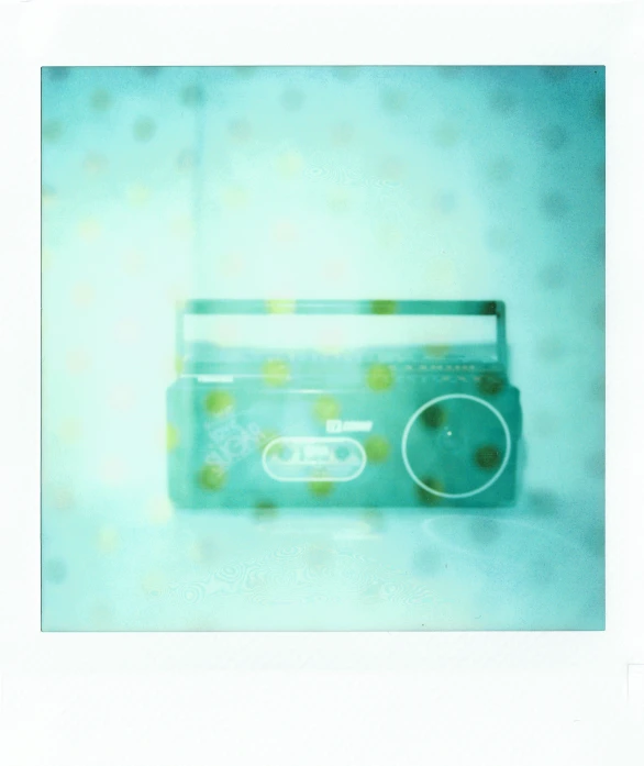 a radio sitting on top of a table, a polaroid photo, by Nathalie Rattner, pop art, ((greenish blue tones)), made of dots, ethereal bubbles, shot on hasselblad