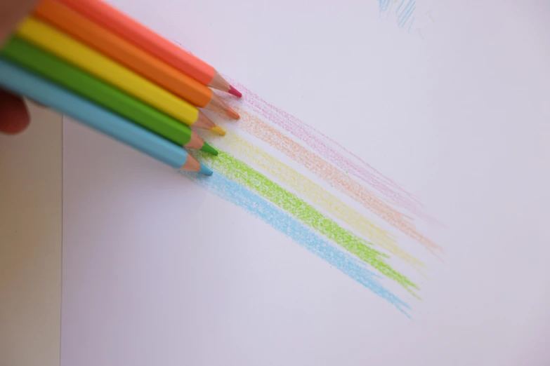 a person drawing with colored pencils on a piece of paper, a child's drawing, by Rachel Reckitt, pexels, rainbow neon strips, photorealistic detail, stipple, orange pastel colors