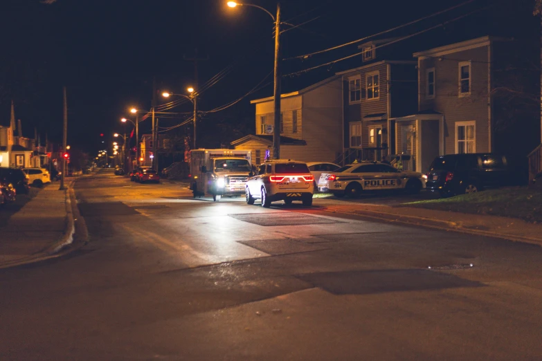 a couple of cars that are sitting in the street, by Ryan Pancoast, pexels contest winner, crime scene, brightly lit, quebec, in a suburb