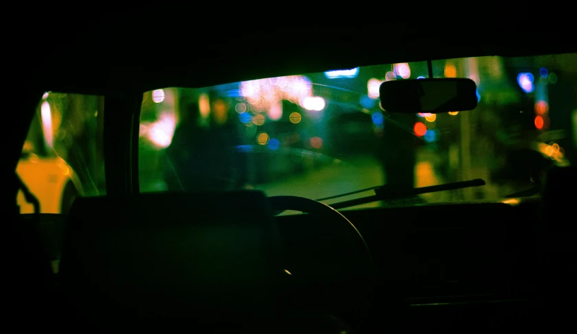 a car driving down a city street at night, an album cover, inspired by Nan Goldin, unsplash, tonalism, green light, taxi, abstract photography, inside of a car