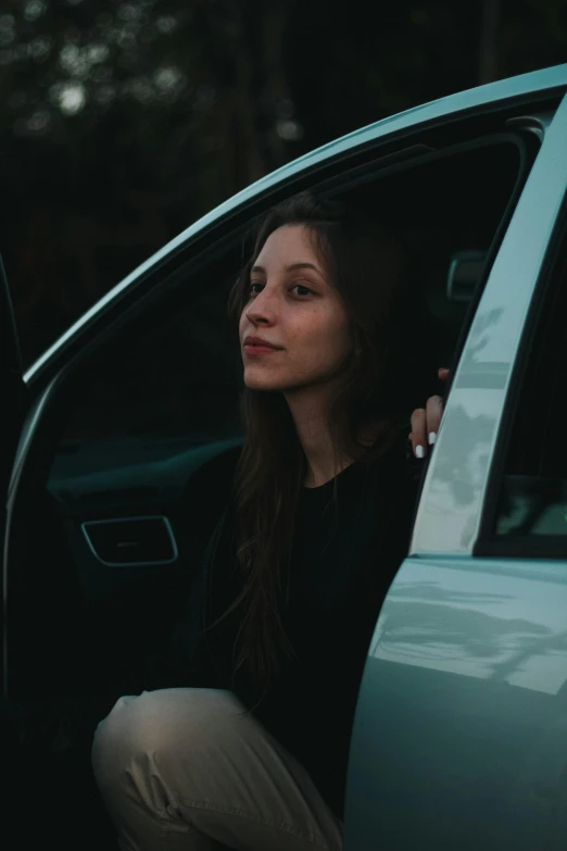 a woman sitting in the driver's seat of a car, inspired by Elsa Bleda, pexels contest winner, renaissance, leaning on door, poor quality, square, girl with dark brown hair