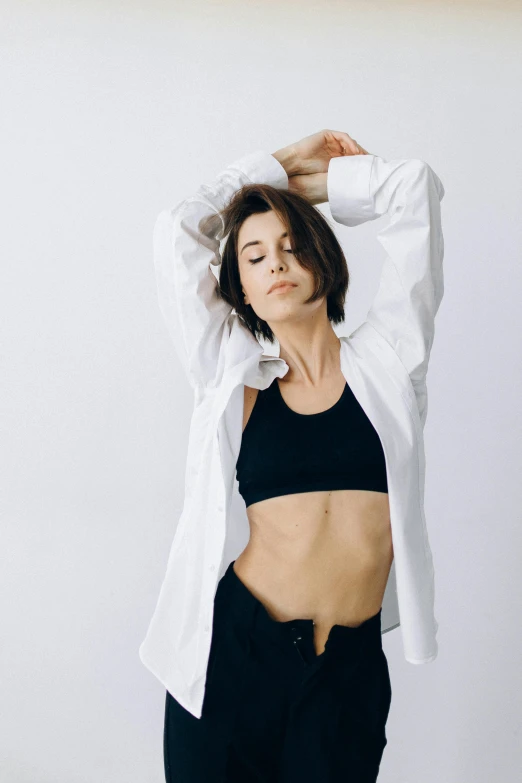 a woman in a white shirt and black pants, trending on unsplash, arabesque, sport bra and shirt, confident relaxed pose, maia sandu hyperrealistic, instagram photo