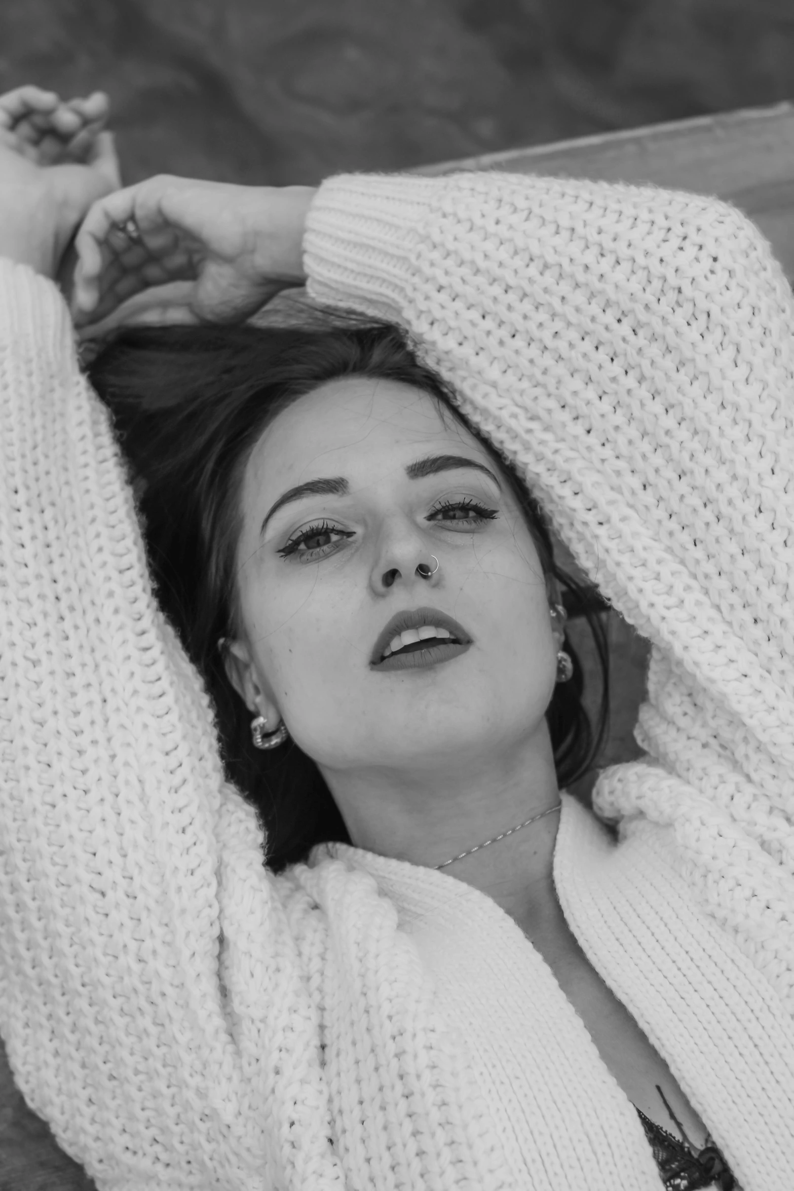 a black and white photo of a woman in a sweater, inspired by Anita Malfatti, chloe bennet, in a chill position, wearing a white sweater, adele