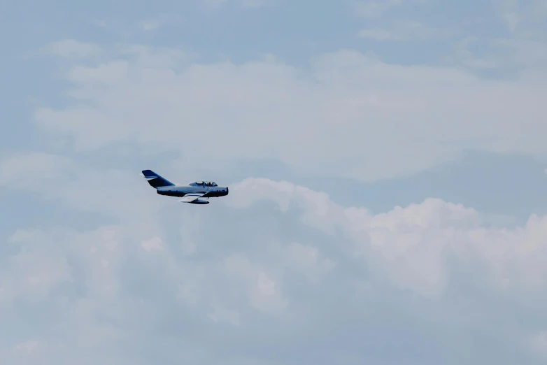 a blue and white airplane flying through a cloudy sky, pexels contest winner, hurufiyya, space shuttle, low quality footage, visible from afar!!, fan favorite