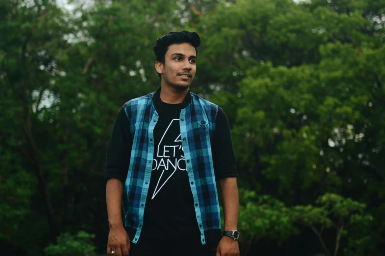 a man standing in front of some trees, by Max Dauthendey, pexels contest winner, hurufiyya, wearing a dark shirt and jeans, avatar image, profile pic, concert photo