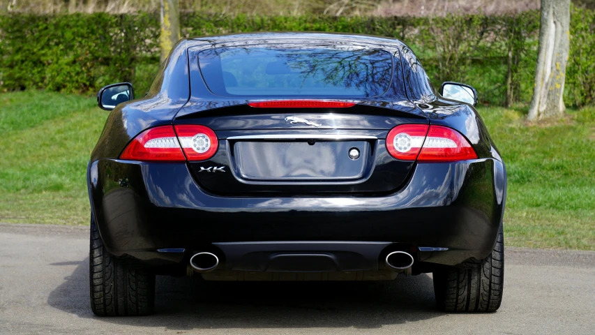 a black sports car parked on the side of the road, by Kev Walker, pexels contest winner, rear facing, jaguar, where a large, stockphoto