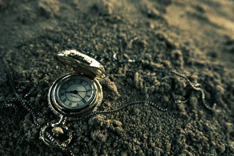 a pocket watch laying in the sand on a beach, an album cover, background image, ancient, thumbnail, sorrow
