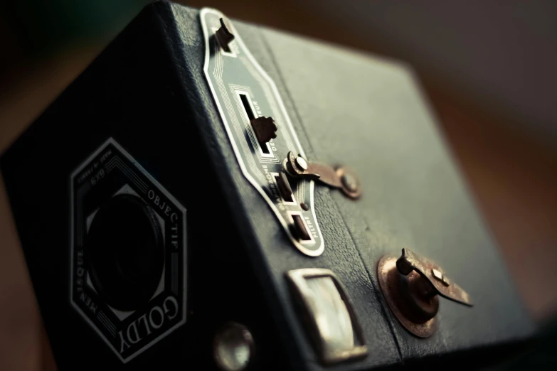 a black suitcase sitting on top of a wooden floor, a polaroid photo, by Adam Marczyński, unsplash, steampunc, radio box, close up shot from the side, soft light from the side