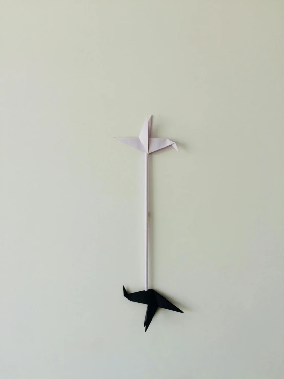 a close up of a paper airplane on a wall, by Jesper Knudsen, kinetic art, black white pastel pink, longsword, vertical orientation w 832, metal dragon tail