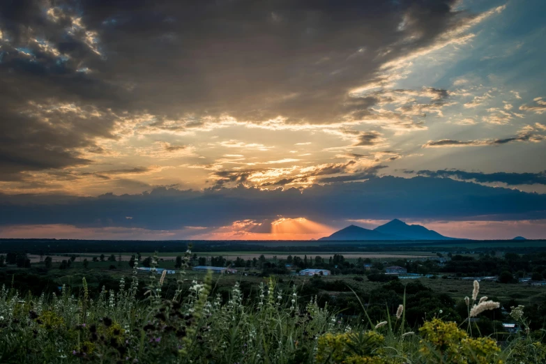 the sun is setting over the mountains in the distance, by Alexander Runciman, unsplash contest winner, prairie, summer setting, new mexico, volcanoes in the background