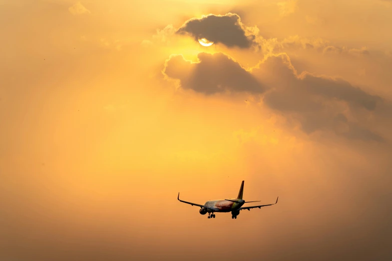 a large jetliner flying through a cloudy sky, by Andries Stock, pexels contest winner, romanticism, bright yellow and red sun, black. airports, a green, thumbnail