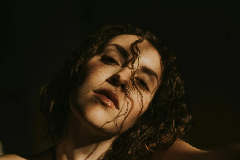 a close up of a woman with wet hair, an album cover, pexels contest winner, low - lighting, curly, portrait image, low iso