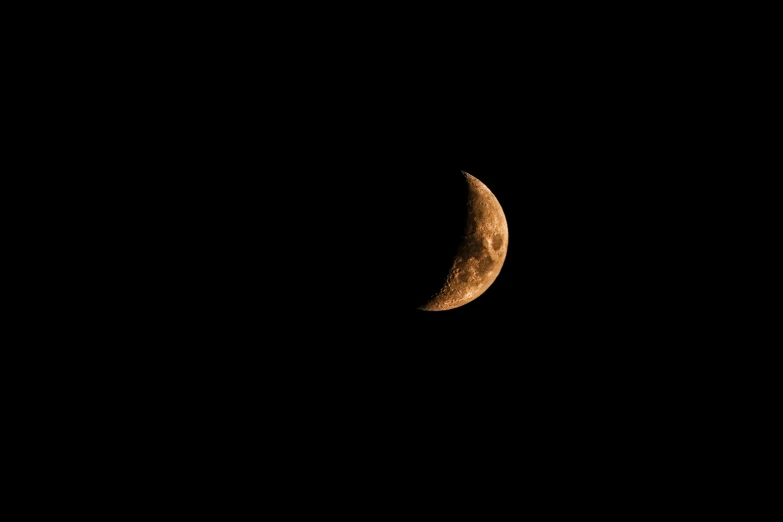 the moon is lit up in the dark sky, an album cover, by Peter Churcher, pexels, orange: 0.5, brown, sickle, curved