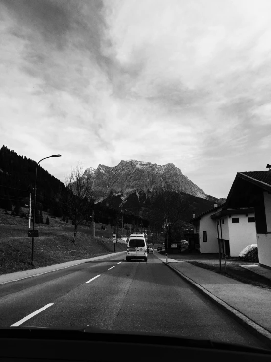 a car driving down a road with a mountain in the background, by Tobias Stimmer, square, black an white, by rainer hosch, van