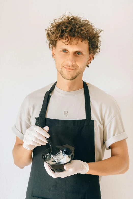 a man in an apron holding a bowl of food, made of ferrofluid, jovana rikalo, professional profile photo, cocky smirk