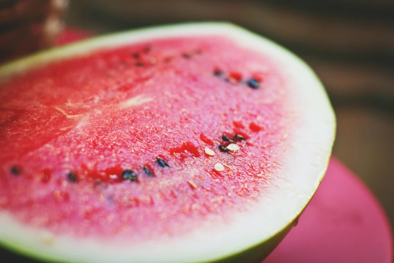 a slice of watermelon sitting on top of a pink plate, pexels, hurufiyya, on a hot australian day, fruit bowl, up-close, carson ellis