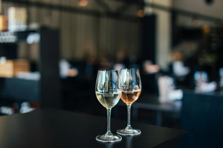 two wine glasses sitting on top of a table, whealan, multiple stories, charcoal and champagne, white