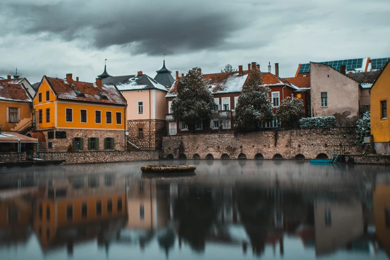 a row of houses next to a body of water, by Sebastian Spreng, pexels contest winner, in legnica, moody colors, panorama, fine art print