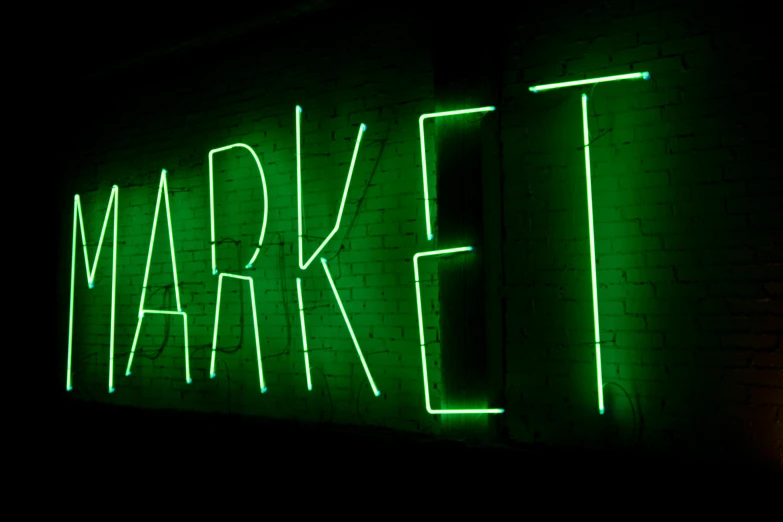 a neon sign on the side of a brick building, pexels, market setting, a green, dark, 3 4 5 3 1