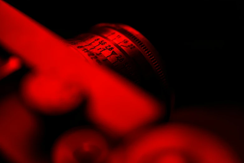 a close up of a knife with a red light in the background, a macro photograph, by Adam Marczyński, red cinema camera, blueprint red ink, red wine, medium shot taken from behind