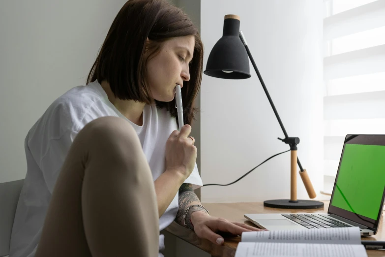 a woman sitting in front of a laptop computer, pexels contest winner, academic art, emerging from her lamp, pen and paper, profile image, casual pose