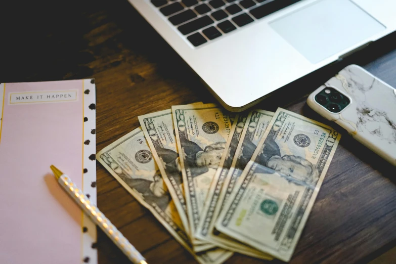 a laptop computer sitting on top of a wooden desk, by Daniel Lieske, pexels contest winner, renaissance, dollar bank notes, thumbnail, film photo, casually dressed