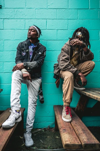 two men sitting on wooden benches in front of a blue wall, by Washington Allston, trending on pexels, graffiti, playboi carti and lil uzi vert, looking off to the side, hemp, dreads