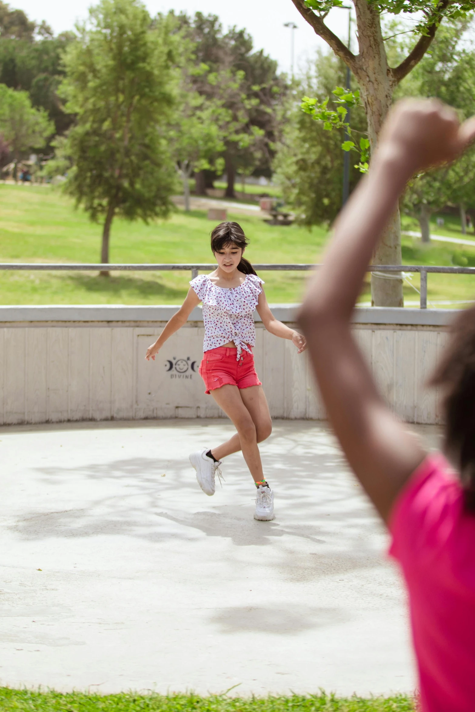 a couple of young girls playing a game of frisbee, an album cover, unsplash, tar pits, rollerskaters, 8 k -, shot with sony alpha