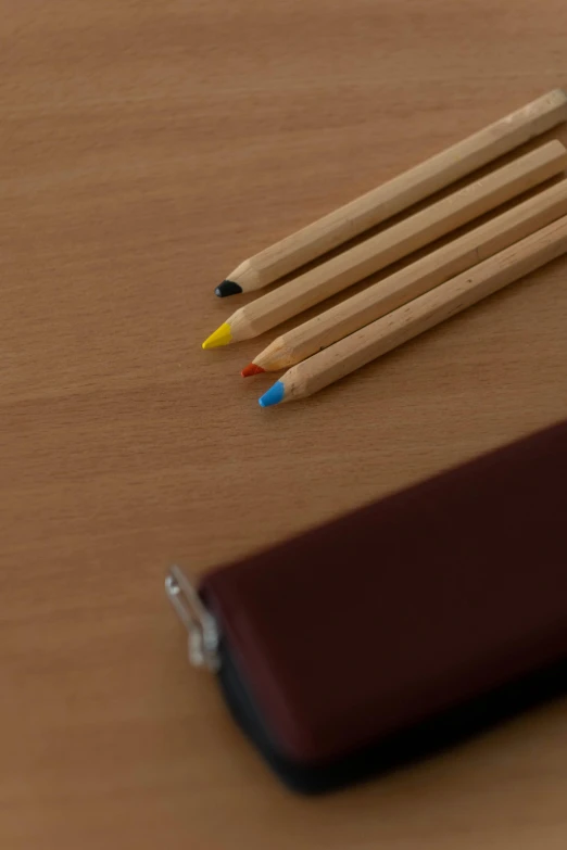 a group of pencils sitting on top of a wooden table, by Yasushi Sugiyama, multicolor, brown, medium-shot, product introduction photo
