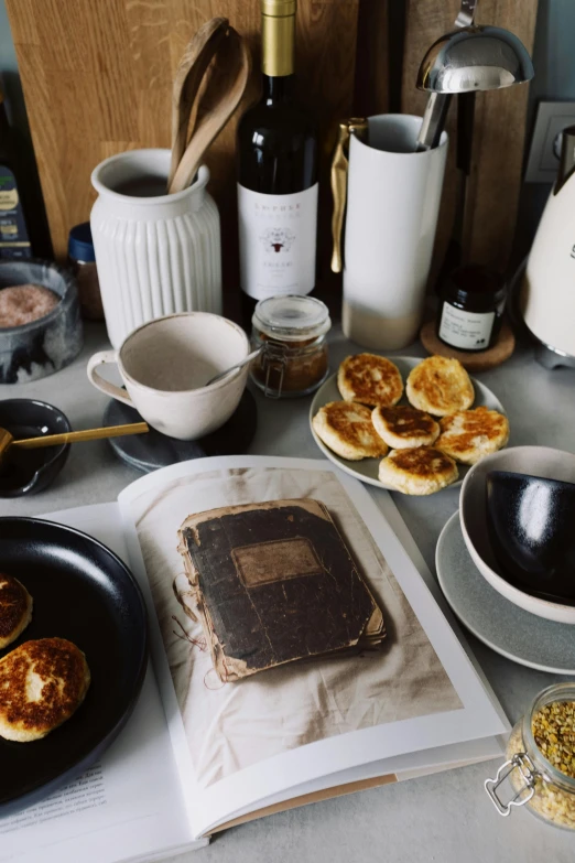 a table topped with plates of food and a book, a still life, unsplash, maple syrup, black, aussie, panoramic