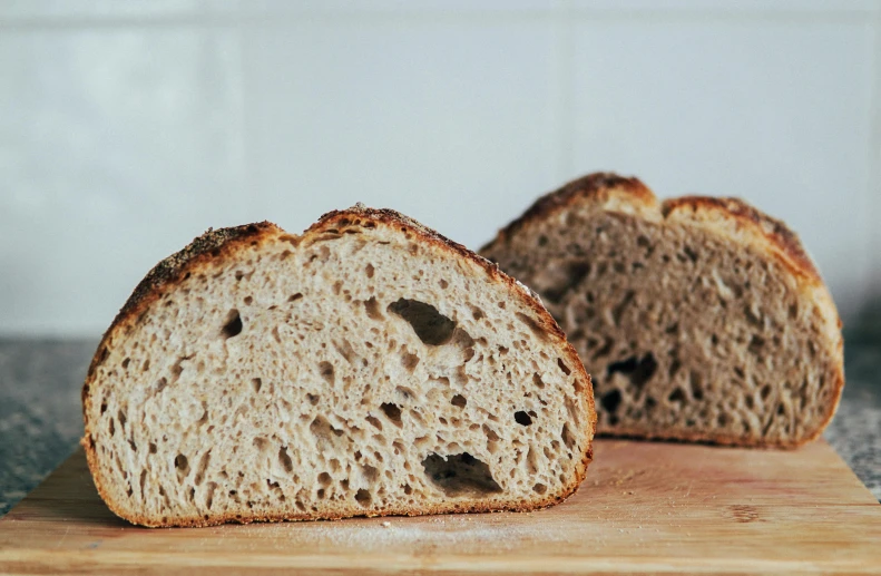 a loaf of bread sitting on top of a cutting board, inspired by Richmond Barthé, unsplash, mineral grains, arched back, very crispy, thumbnail
