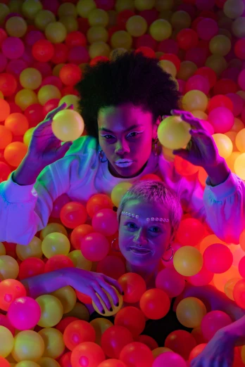 a group of people playing in a ball pit, an album cover, interactive art, glowing white neon eyes, lesbian art, ( ( dark skin ) ), high quality photo