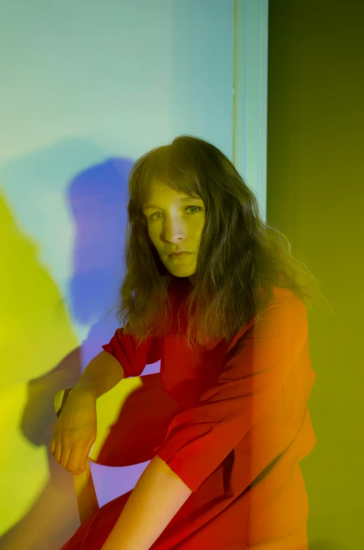 a woman in a red dress sitting on the floor, an album cover, inspired by Grethe Jürgens, trending on pexels, her iridescent membranes, looking threatening, fluorescent, studio picture