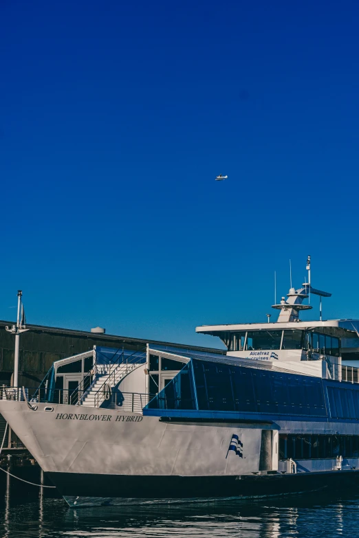 a large white boat sitting on top of a body of water, by Eero Snellman, flying aircrafts, clear blue skies, seen from outside, port