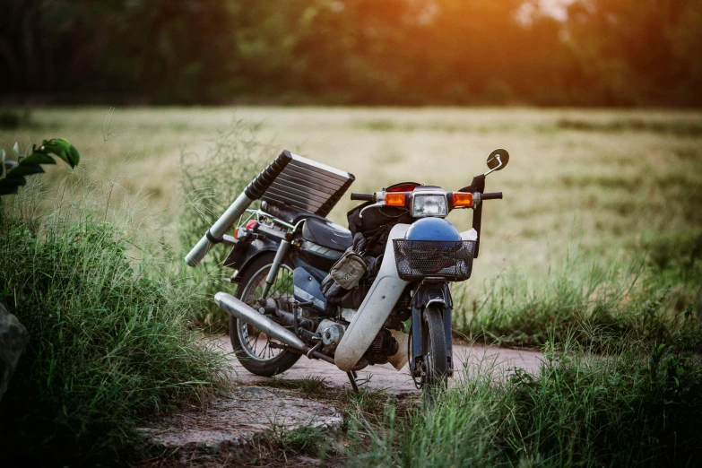 a motorcycle parked on the side of a dirt road, unsplash, photorealism, broken parts, in style of thawan duchanee, hot summer day, maintenance photo