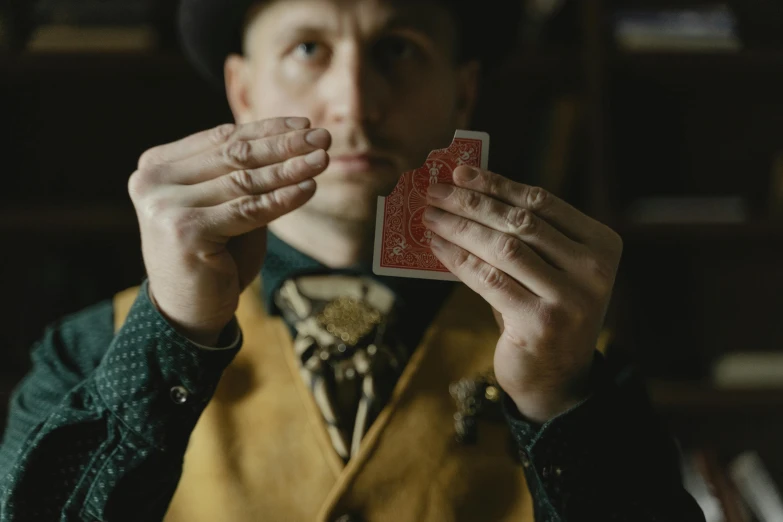 a man holding a deck of cards in his hands, a portrait, by Daniel Lieske, pexels contest winner, renaissance, costumes from peaky blinders, steampunk imagery themed, medium shot of two characters, cardistry
