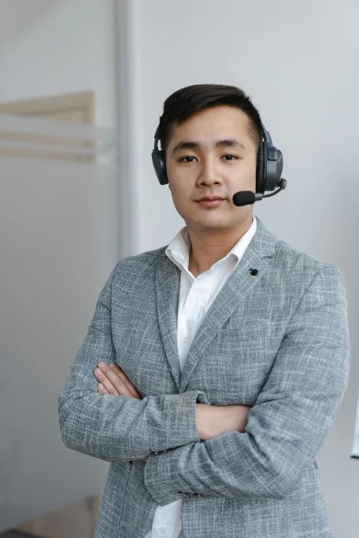 a man wearing a headset standing with his arms crossed, reddit, asian descend, professional photo