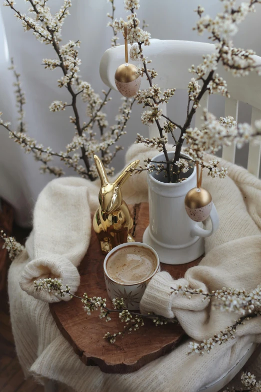 a wooden table topped with a vase filled with flowers, by Lucia Peka, trending on instagram, hot cocoa drink, golden orbs, bunny, branches