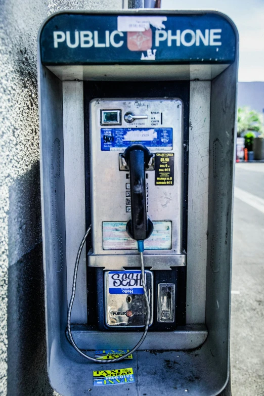 a public phone sitting on the side of a street, bay area, blue and silver, heavy lines, square