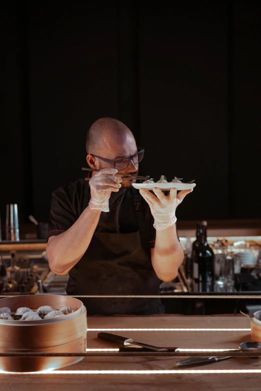 a man sitting at a table eating a piece of food, chef platypus, profile image, oysters, on a wooden tray