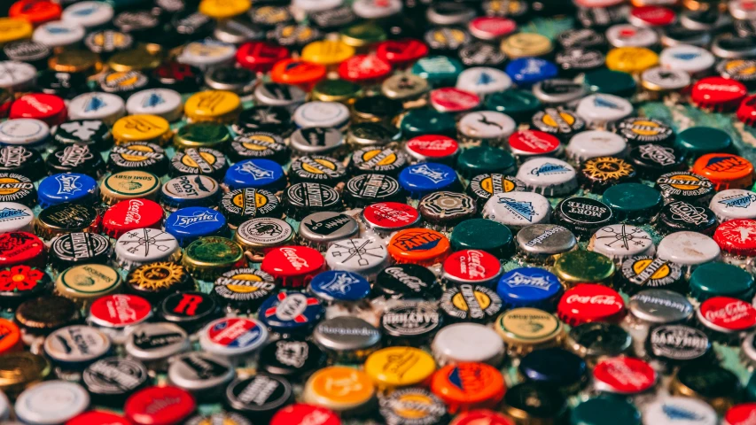 a pile of beer bottle caps sitting on top of a table, pexels contest winner, logos, top selection on unsplash, round-cropped, multicoloured