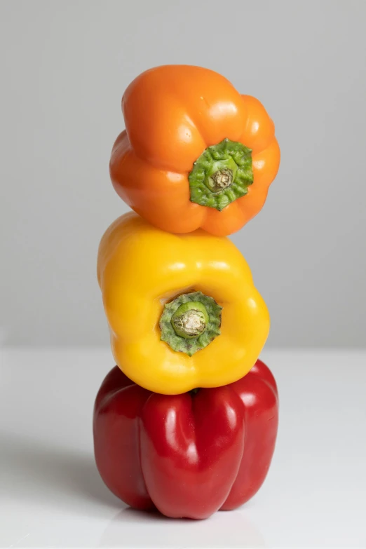 three bell peppers stacked on top of each other, inspired by Albert Joseph Pénot, balances, 3/4 view, mix, tall