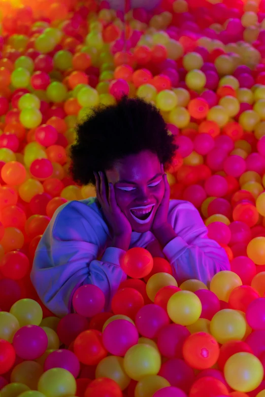 a woman in a ball pit talking on a cell phone, neon glowing eyes, smiling down from above, press shot, neon jungle