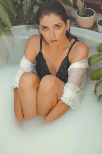 a woman sitting in a bath tub next to a potted plant, a colorized photo, inspired by Elsa Bleda, trending on pexels, renaissance, sexy look at the camera, isabela moner, 🤤 girl portrait, thighs close up