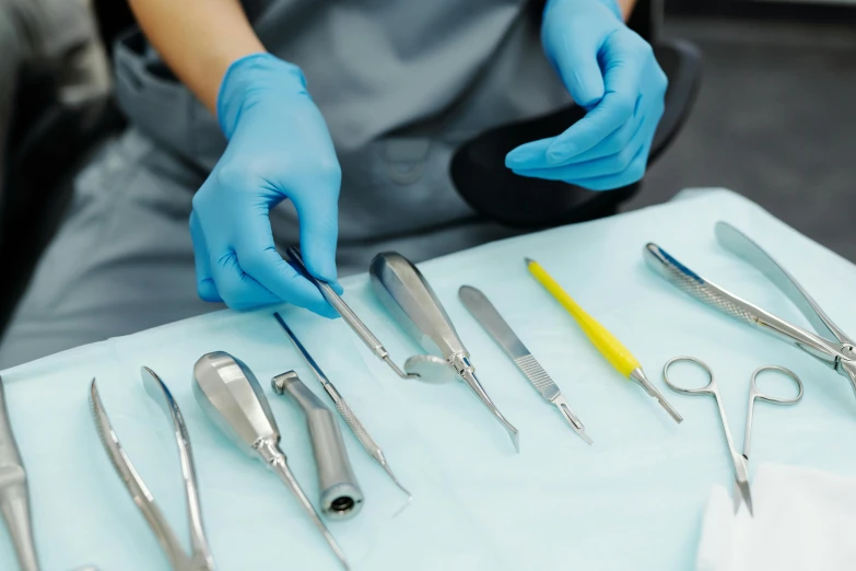 a person in blue gloves holding a pair of scissors, surgical implements, all teeth, scrubs, thumbnail
