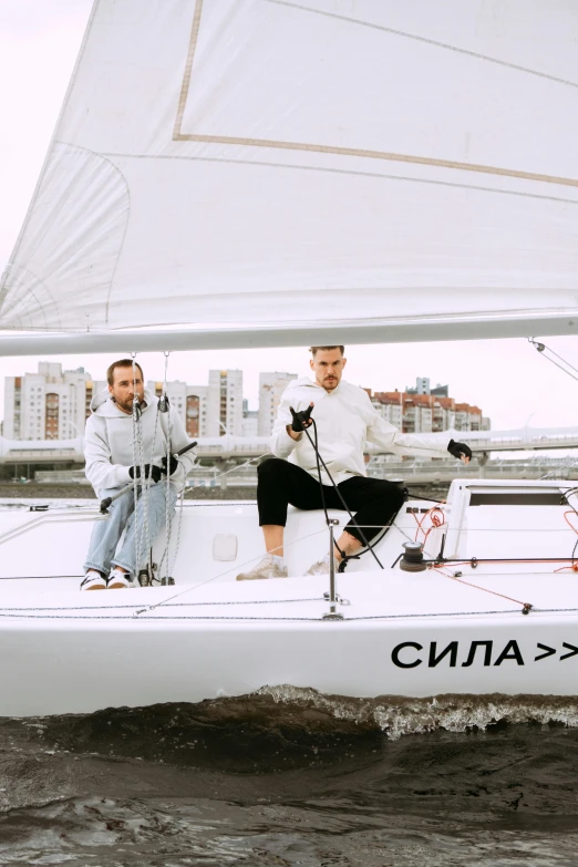 two men are sitting on a sailboat in the water, an album cover, by Julia Pishtar, neo-dada, gta in moscow, wearing a track suit, high quality photo, white