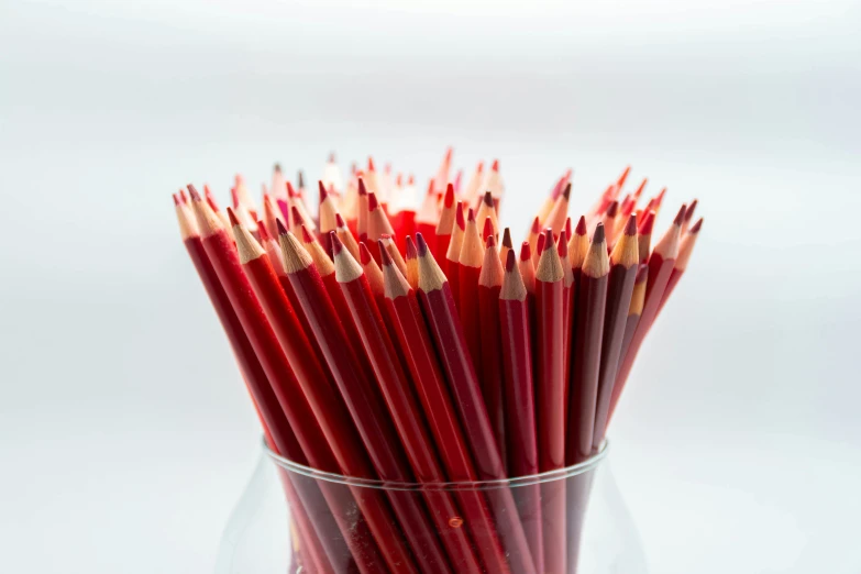 a glass filled with lots of red pencils, pexels, hyperrealism, close up food photography, pale red, venetian red, high quality product image”
