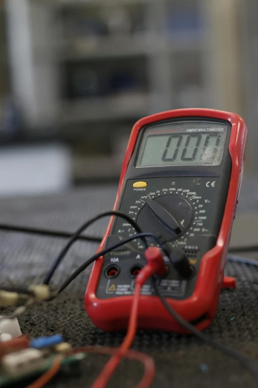 a digital multimeter sitting on top of a table, pexels, stood in a lab, red wires wrap around, vibration, headshot