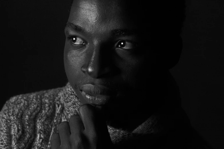 a black and white photo of a man in a sweater, by Maurycy Gottlieb, unsplash, realism, adut akech, low key lights, photograph taken in 1989, black young woman