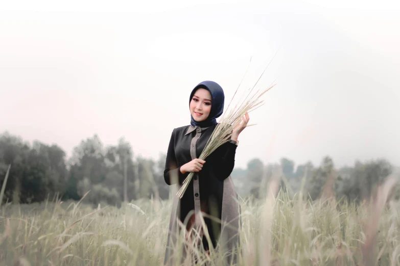 a woman standing in a field of tall grass, a picture, by Basuki Abdullah, unsplash, hurufiyya, 🤤 girl portrait, icon, background image, formal attire